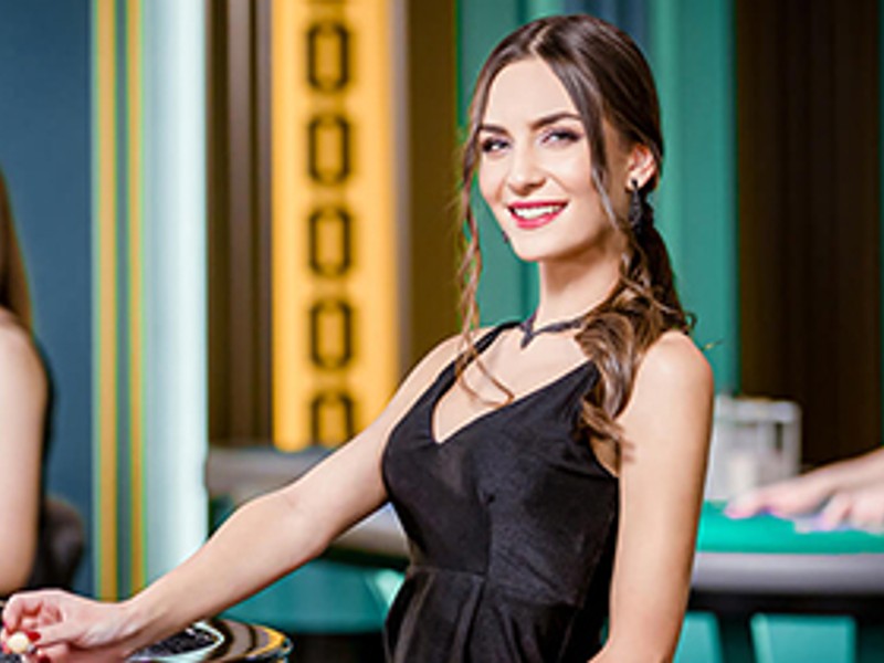 Hình ảnh người chia bài chuyên nghiệp tại bàn Baccarat trực tuyến của win23, không gian sang trọng